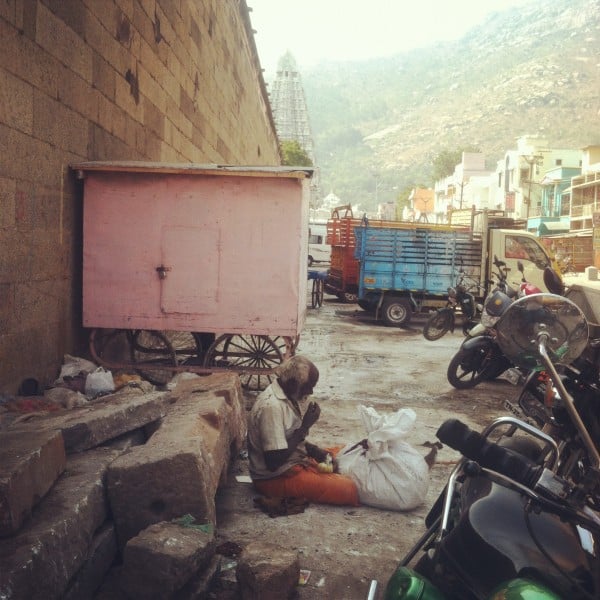 A homeless man.  His backdrop is the ancient temple and the holy mountain.  Real life.