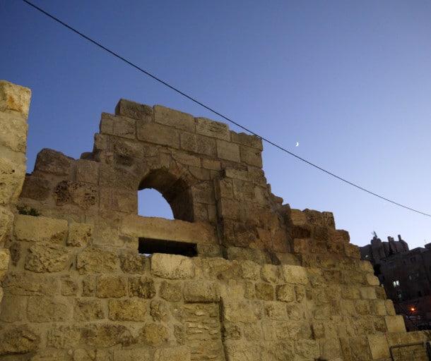 A crescent moon shines over The Western Wall