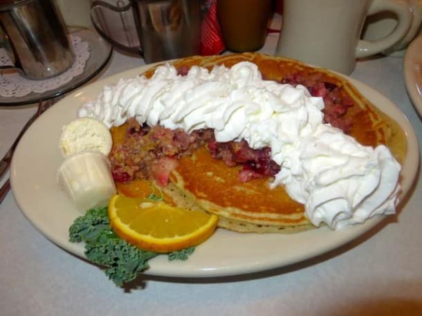 Cranberry, apple and granola pancakes topped with whipped cream at Elmo’s Diner