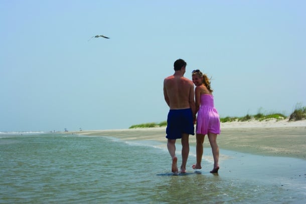 A couple strolls a Charleston beach (Credit: Charleston CVB)