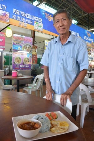Mr. Low serving us nasi lemak