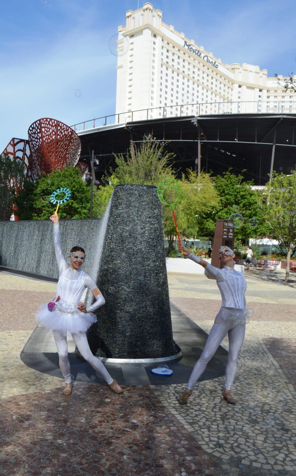 Performers in front of the water wall at the opening of The Park