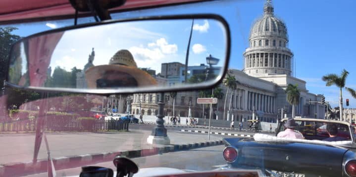 Riding in a classic convertible passing El Capitolio, or National Capitol Building in Havana, Cuba (Credit: Caitlin Martin)