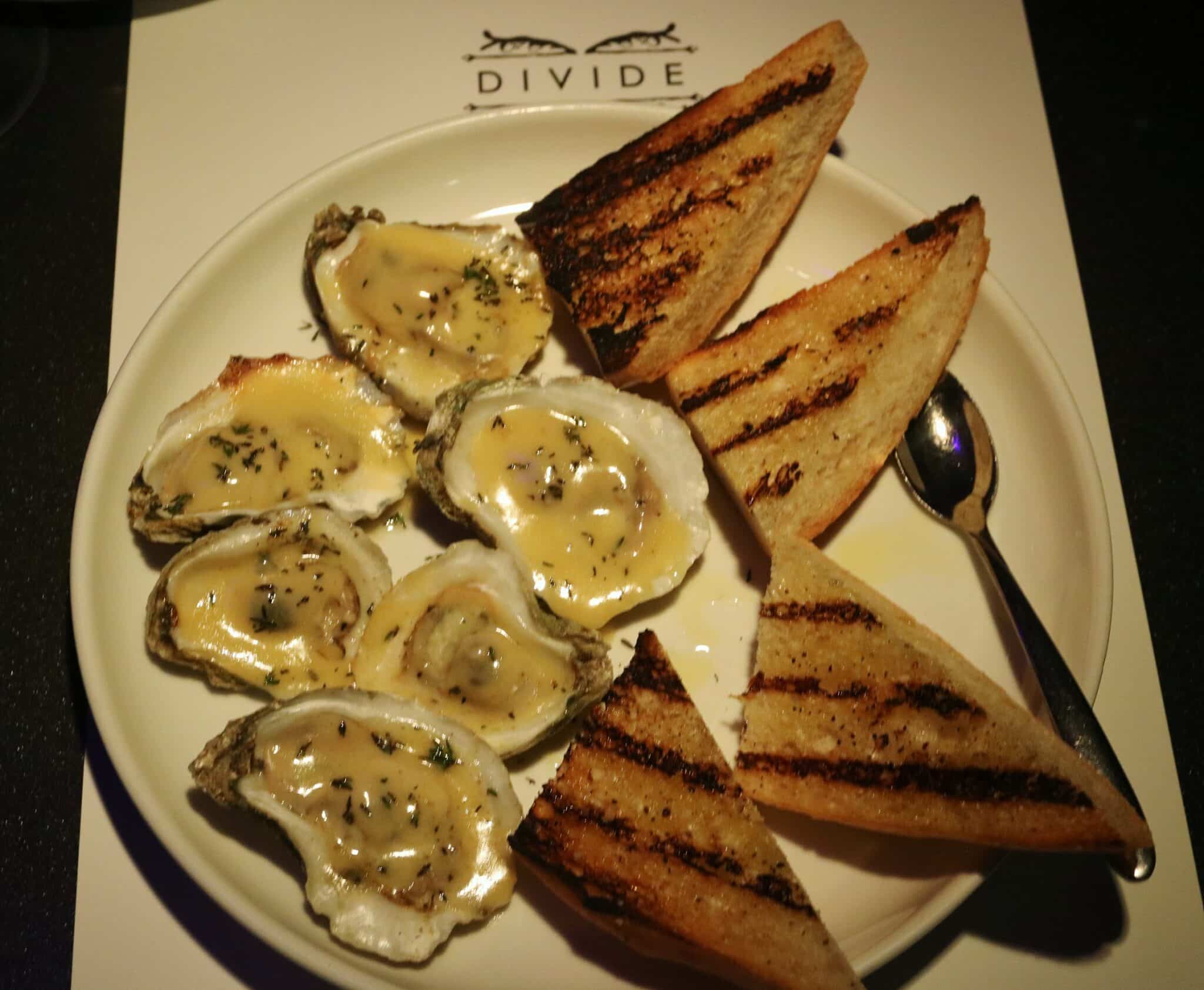 Char-grilled oysters with apricot cocktail sauce and garlic confit butter at Rebelle