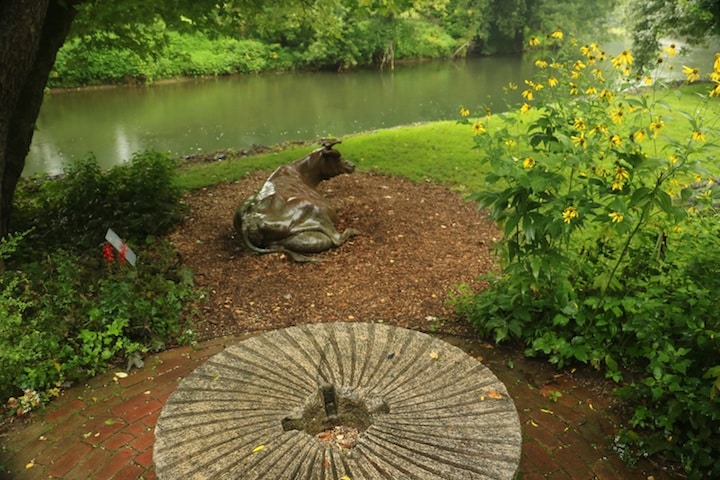 Millstone and cow sculpture along the Brandywine