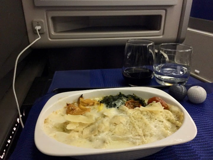 Entree: "Cacio e Pepe ravioli" with parmesan cream sauce, roasted red and yellow tomatoes, garlic spinach, and more parmesan